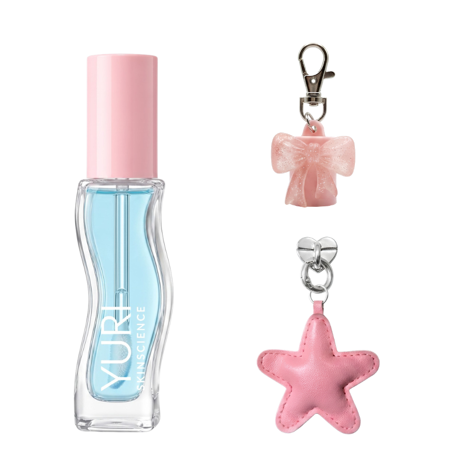 Yuri Skinscience pH reactive lip tint oil in a curved blue glass bottle with pink cap, shown with the glitter bow bag charm and pink leather star phone charm included
